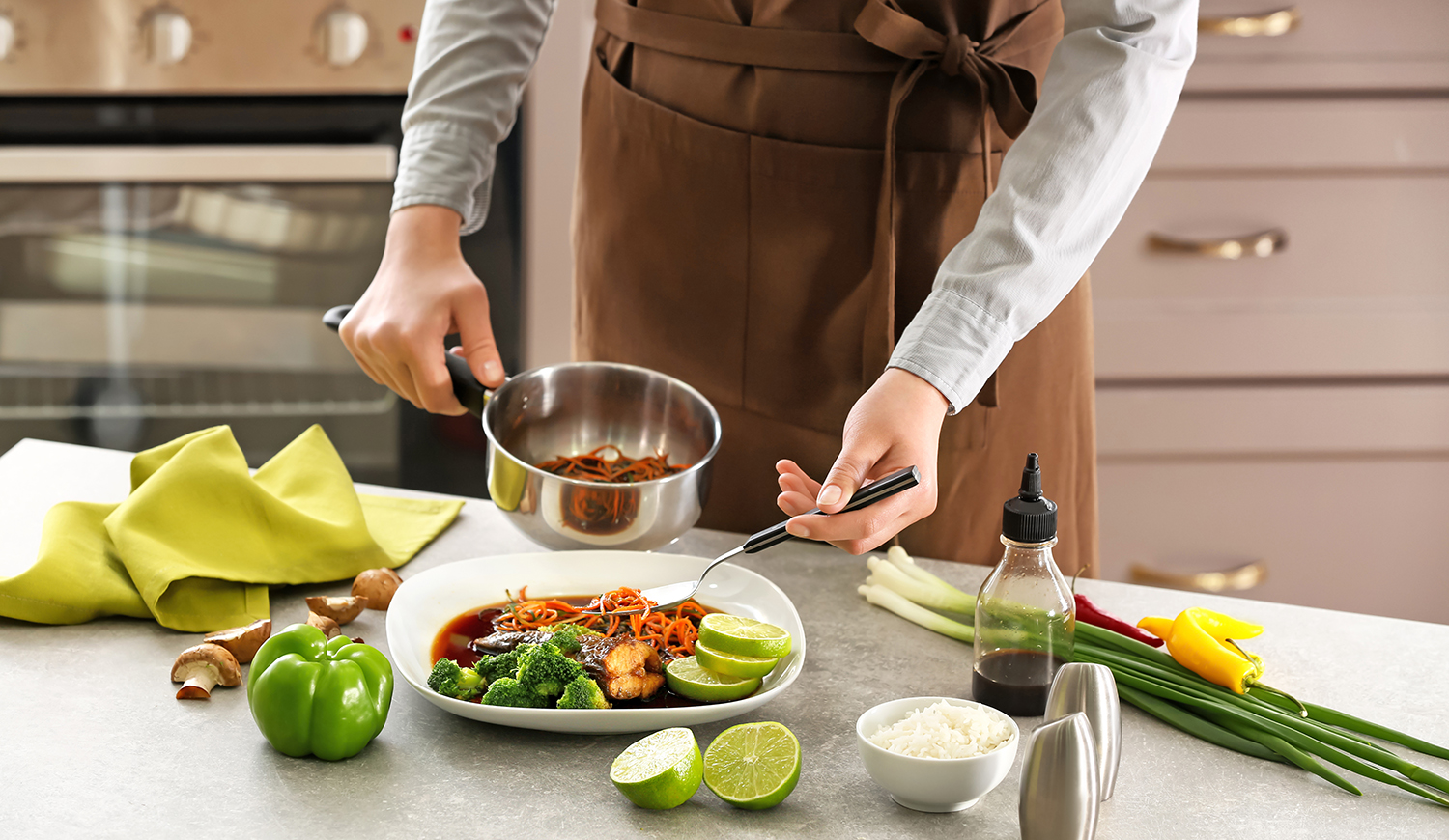 nő sárgarépát szószban tesz tányérra a konyhában