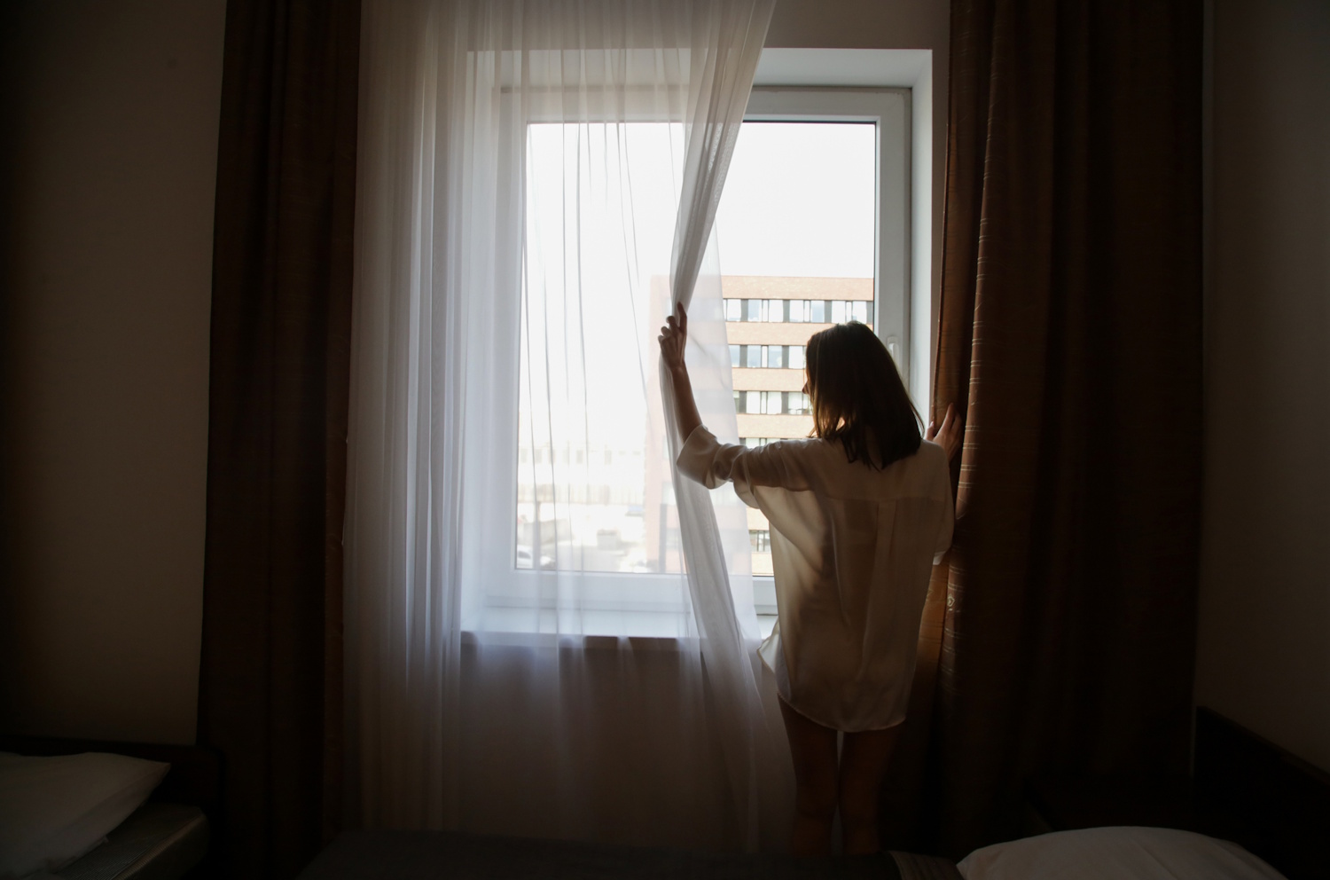 Egy nő néz ki az ablakon