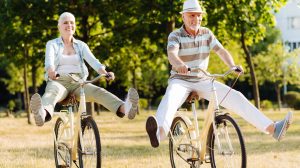 idősebb nő és férfi bicikliznek a mezőn