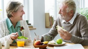 Egy idős pár ül az asztalnál és eszik