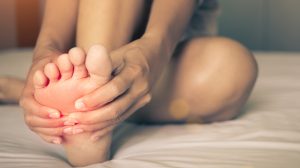 Egy nő fájlalja a lábfejét