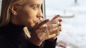 fiatal szőke nő gyömbérteát iszik