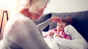 nagymama az unoka lázát méri az ágyban