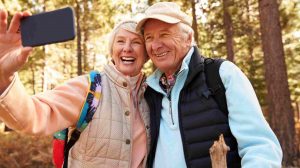 idős házaspár ősszel kirándul miközben fotózzák magukat