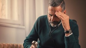 idős férfi gondterhelten nézi a fonendoszkópot