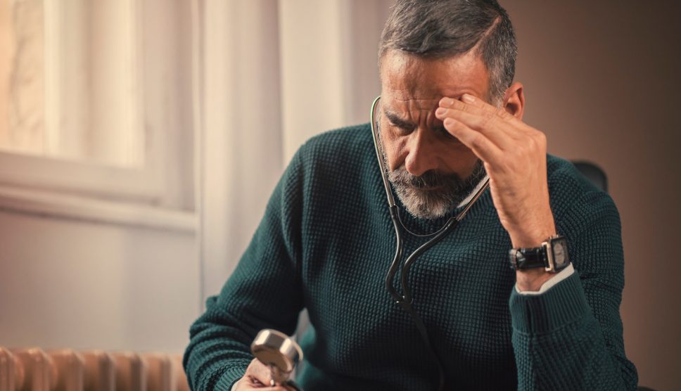 idős férfi gondterhelten nézi a fonendoszkópot