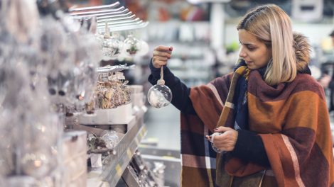 karácsonyi dekoráció között válogat egy nő a boltban