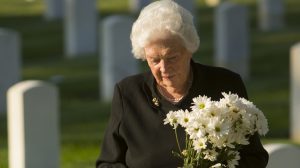 idős néni krizantémmal a temetőben krizantém árak 2025