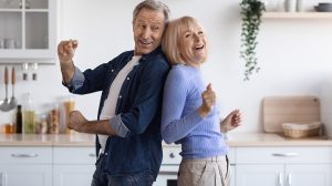 Boldog idős házaspár táncolnak együtt a konyhában