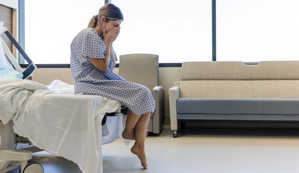 fiatal nő sír a nőgyógyászati vizsgálóban