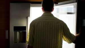 Egy férfi áll a hűtő előtt