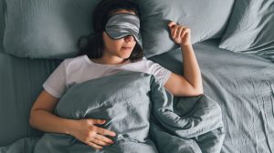 Egy lány alszik a szürke ágyában