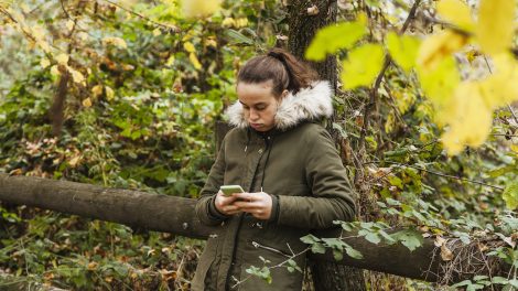 tinédzser lány az erőben a telefonját nyomkodja