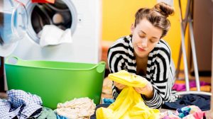 nő nézegeti a ruhákat mosás után