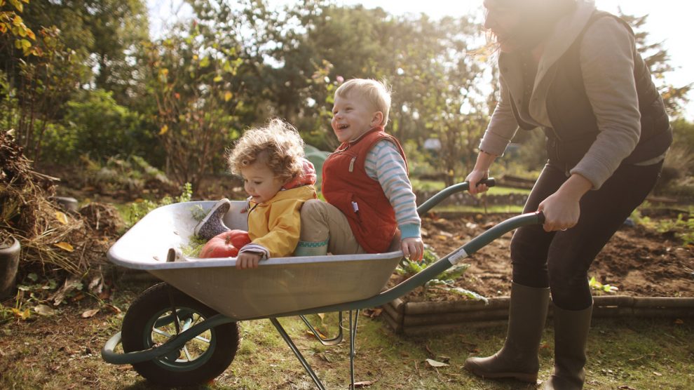 anyuka két kisgyerekével játszik ősszel a kertben