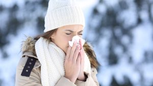 Egy nő fújja az orrát télen
