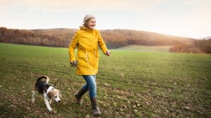 idősebb nő kutyát sétáltat
