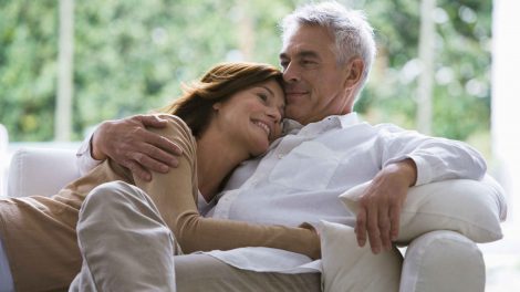 középkorú szerelmespár egymáshoz bújik a kanapén