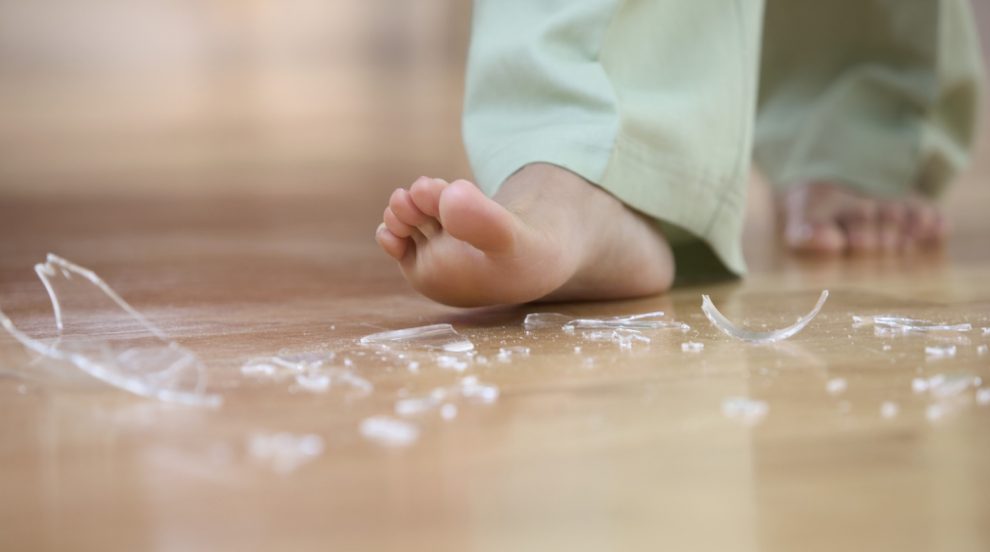 üvegszilánkok felé közelít a meztelen talpával egy nő