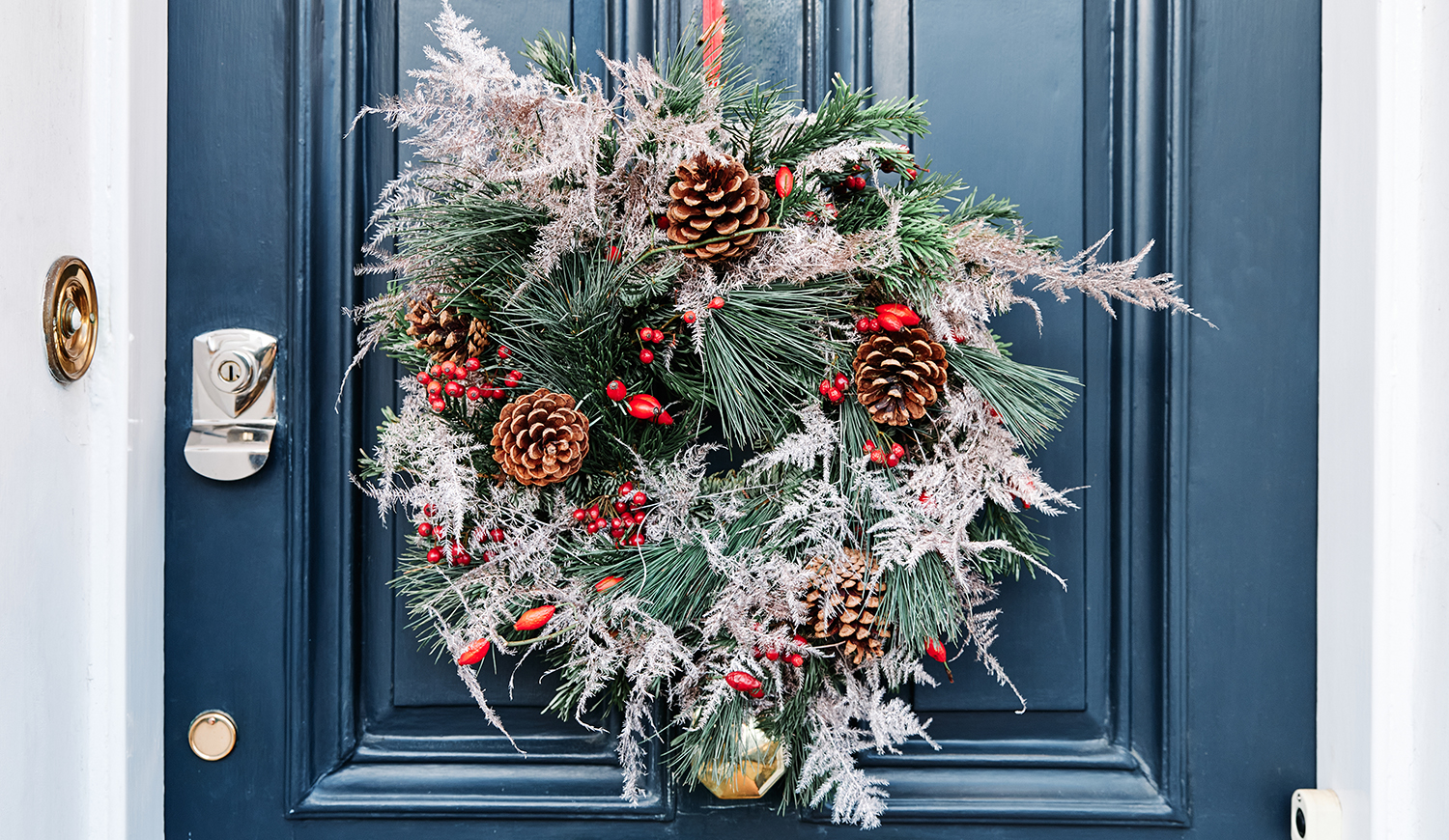 Adventi koszorú lóg egy kék ajtón