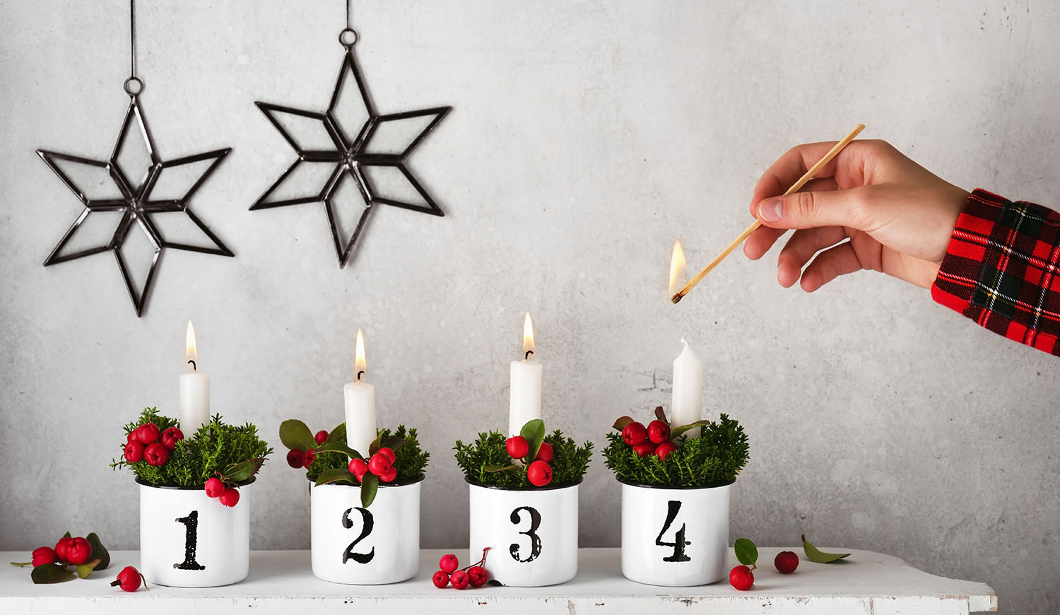 lány meggyújtja a negyedik gyertyát az adventi koszorún