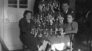 régi retró karácsonyfa előtt ülnek emberek