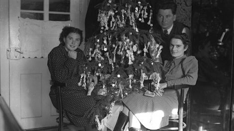 régi retró karácsonyfa előtt ülnek emberek