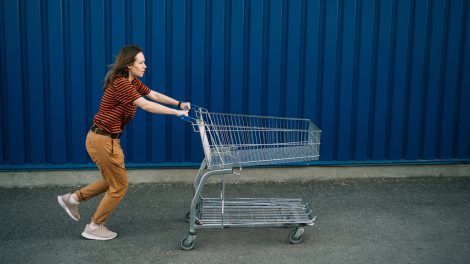 bevásárlókocsit tol vissza egy nő a helyére