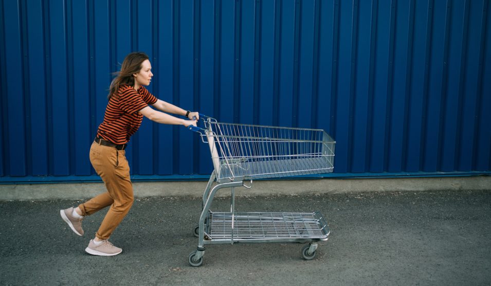 bevásárlókocsit tol vissza egy nő a helyére