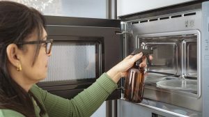 nő ecettel takarítja a mikrót