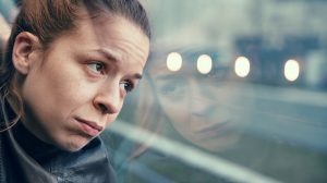 Egy nő fáradtan néz ki az ablakon