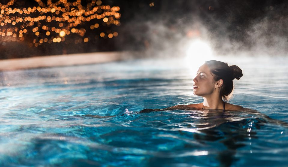 Nő úszik a gőzfürdős medencében