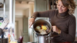 habos húslevest szűr át egy háziasszony a konyhában