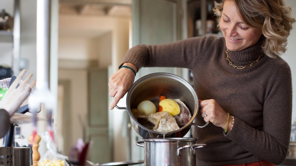 habos húslevest szűr át egy háziasszony a konyhában