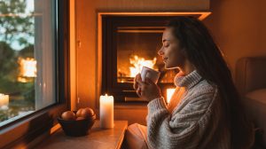 illatos gyertya káros stílusos nappaliban gyertyát gyújt a lány