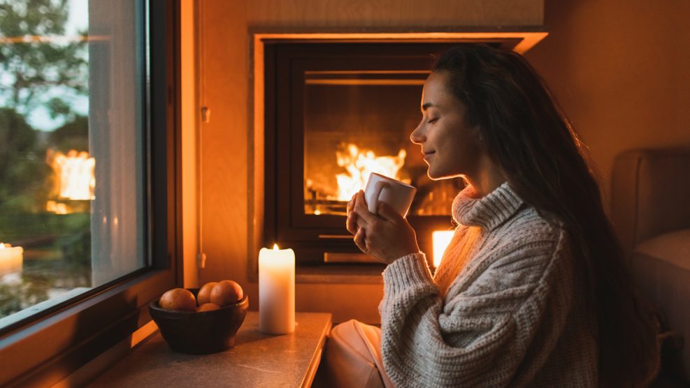 illatos gyertya káros stílusos nappaliban gyertyát gyújt a lány
