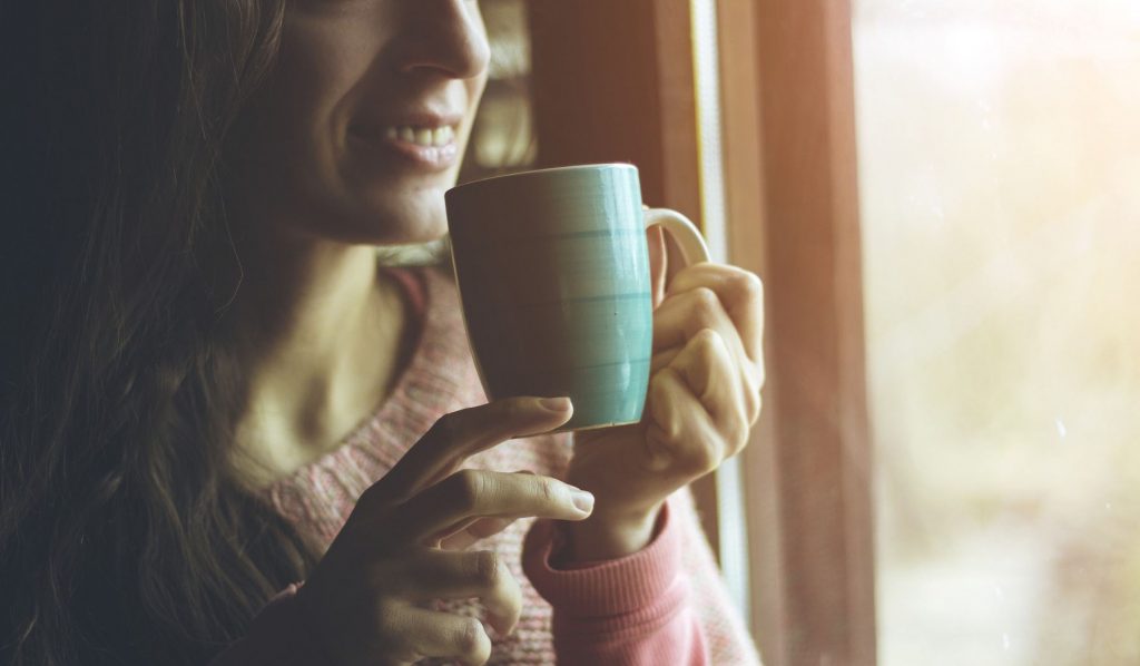 Nő bögréből iszik kávét