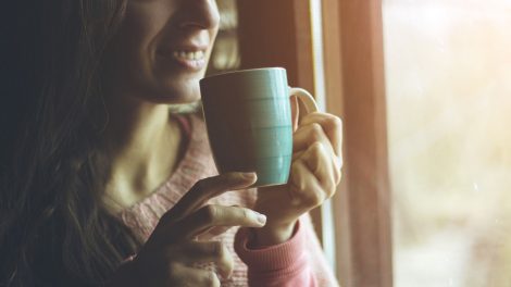 Nő bögréből iszik kávét