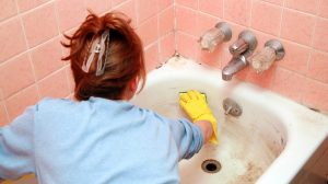 koszor fürdőkádat takarít egy nő