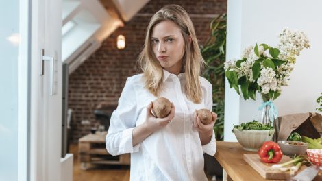 lány vidáman a konyhában krumplival krumplit főz