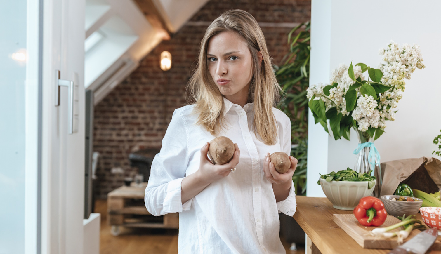 lány vidáman a konyhában krumplival krumplit főz