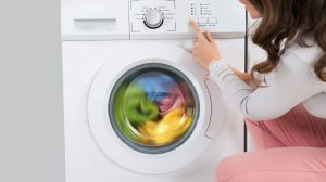 nő elindítja a mosógépet