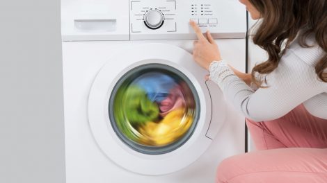nő elindítja a mosógépet