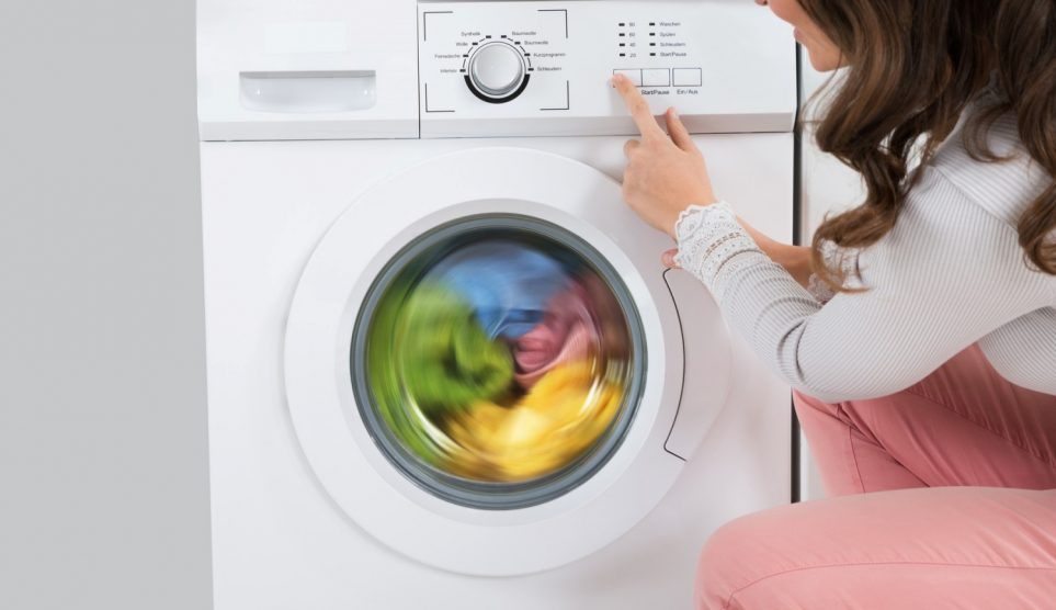 nő elindítja a mosógépet