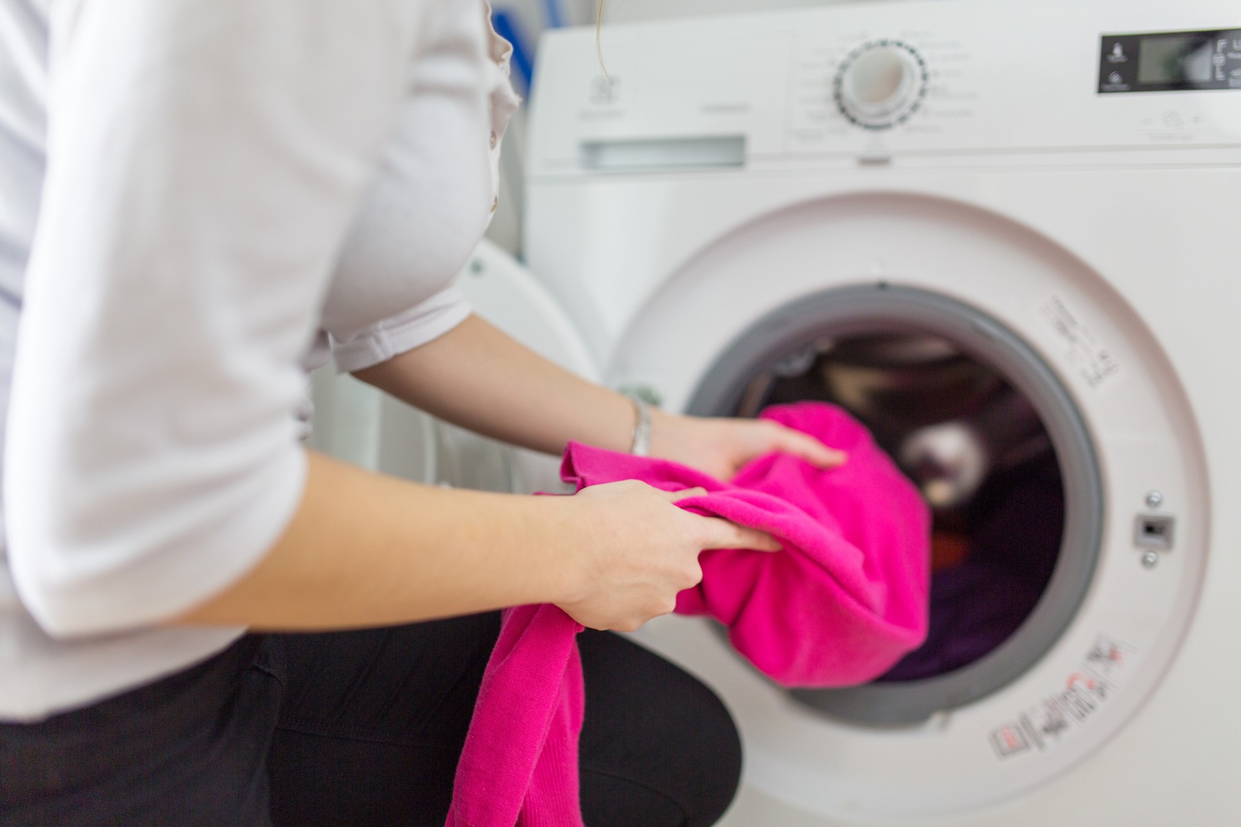 nő mosógépbe pakol