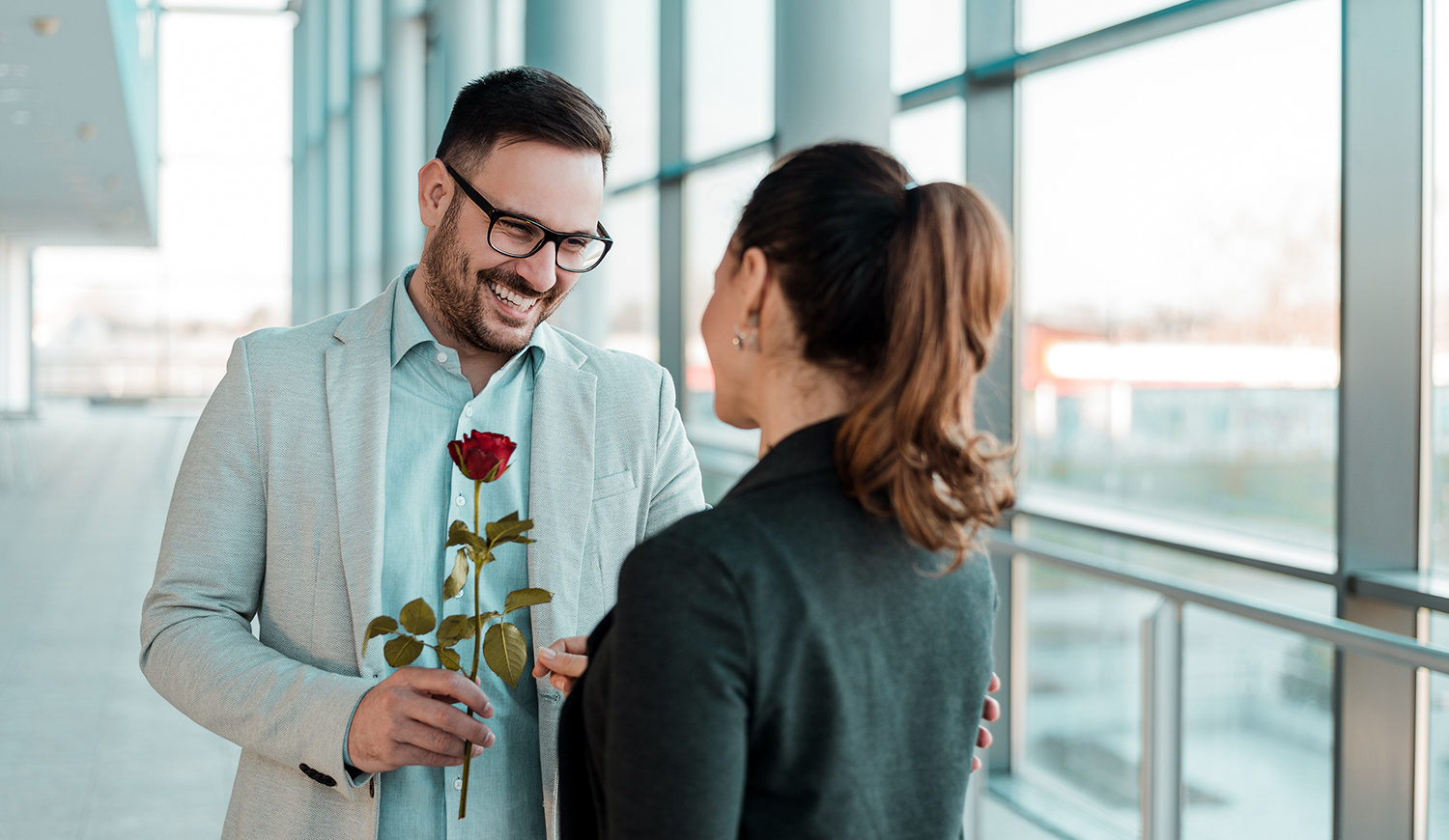 Jóképű üzletember rózsát ad a munkahelyén egy hölgynek