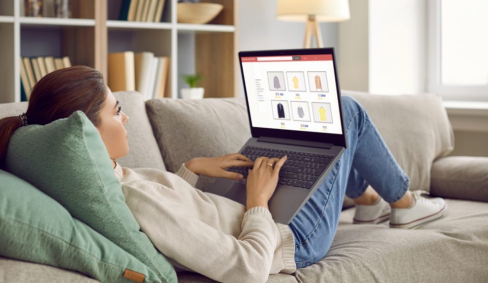 Nő a kanapén fekszik ölében laptoppal, és online vásárol
