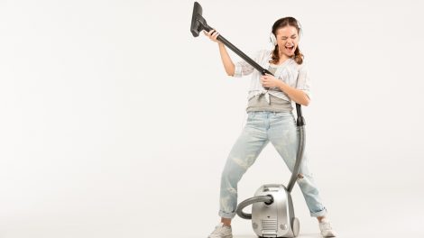 fiatal lány nagyon boldogan porszívózik