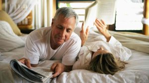 középkorú pár az ágyban olvas