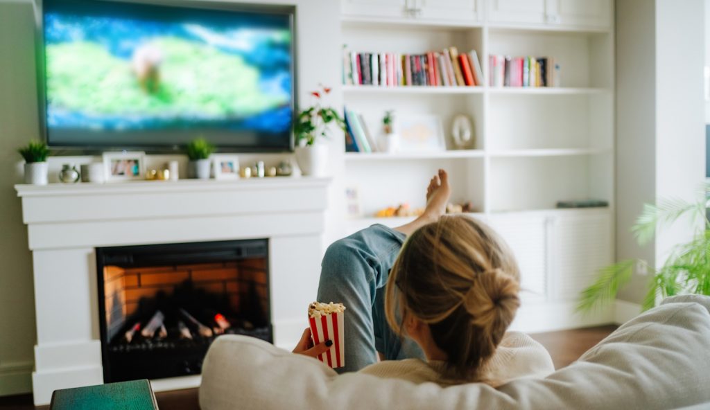 reklámok a netflixen nézi egy nő a kanapén